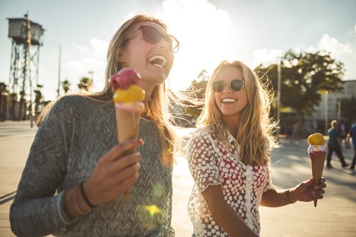 Two girls laughing and eating ice cream