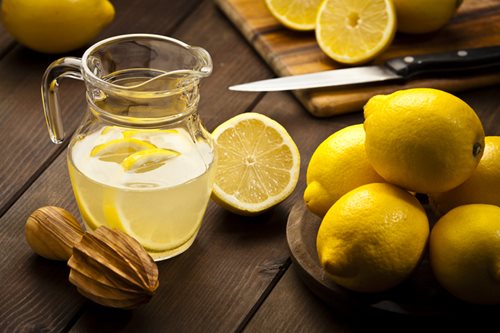 lemons with pitcher of lemonade
